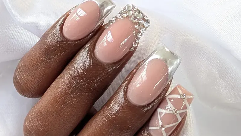 Long square nail extensions with a silver chrome French tip and crystals